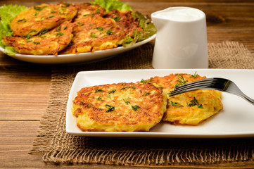 Potato pancakes on brown wooden table.