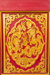 Golden dragon decorated on wood carved on red door, Chinese style in Dragon Temple Kammalawat (Wat Lengnoeiyi) in Nonthaburi, Thailand