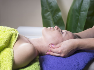 Obraz na płótnie Canvas Young beautiful woman gets massage at spa