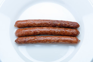 hunting smoked sausage on a white plate closeup