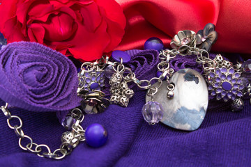 Valentine red rose, satin and purple background with silver bead necklace and mother of pearl pendant