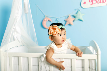 little girl standing in a crib