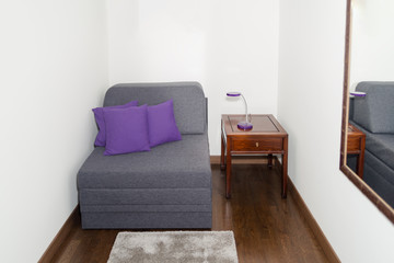Comfy Gray Armchair with Purple Pillow near a Small Table