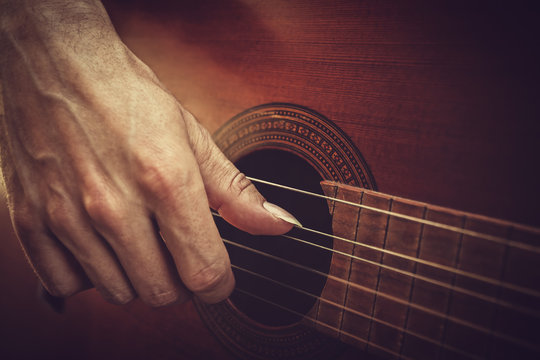 guitarist hand on strings macro. playing acoustic guitar.