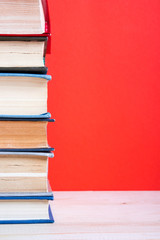 Open hardback book on wooden deck table and red background