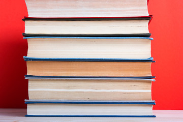 Open hardback book on wooden deck table and red background