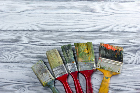 Artistic, artist, art. Used artist paintbrushes mastehin on wood background. 