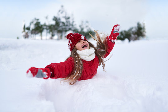 the child falls into  snow and laughing