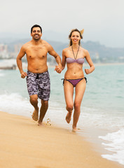 Young couple runs near the sea