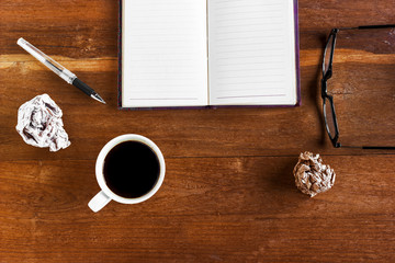 Working with blank notebook on wooden desk background with coffe