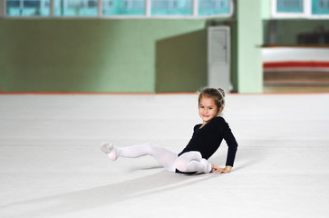 Fototapeta na wymiar little girl fell training in rhythmic athletics