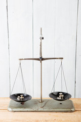 Balance scales on white wooden background