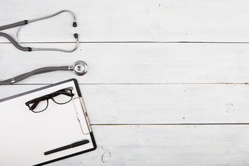 Workplace of doctor - stethoscope, medicine clipboard, glasses a