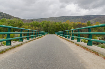 Fototapeta na wymiar View on road with green shabby railing