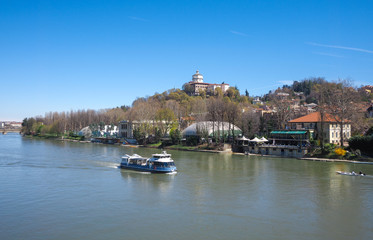Fototapeta premium Tourist boat on Po river in Turin, Piedmont, Monte dei Cappuccini church in background
