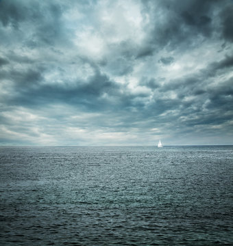 Fototapeta Sailing Boat at Stormy Sea. Dark Background.