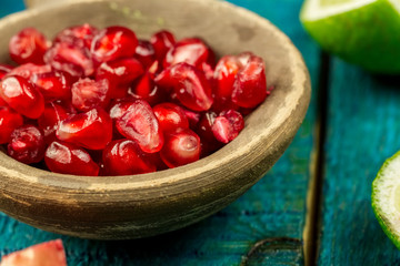 Ripe lime, pomegranate fruit on wooden vintage background. Healthy vegetarian food. Recipe, menu, mock up, cooking.
