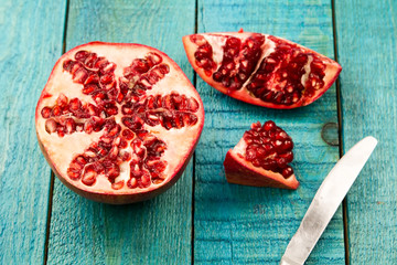 Ripe pomegranate fruit on wooden vintage background. Healthy vegetarian food. Recipe, menu, mock up, cooking.