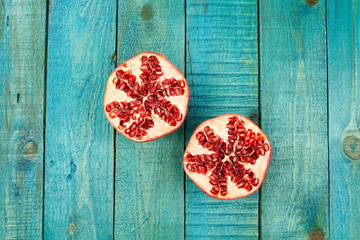 Ripe pomegranate fruit on wooden vintage background. Healthy vegetarian food. Recipe, menu, mock up, cooking.