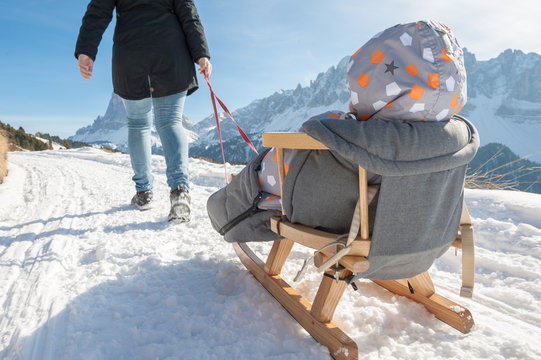 parent pulls the sledge with his son