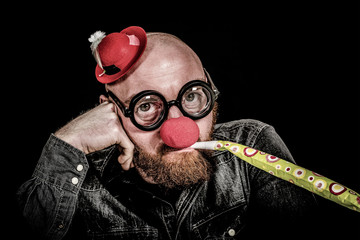 Man with beard wearing red nose and funny hat