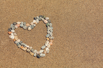 Fototapeta na wymiar heart shaped pebbles on beach. valentines day background.