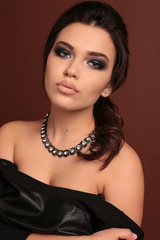 fashion studio portrait of beautiful woman with dark hair and evening makeup, with bijou