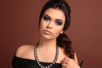 fashion studio portrait of beautiful woman with dark hair and evening makeup, with bijou