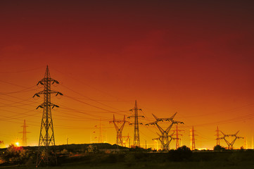 Fototapeta na wymiar high voltage electric pillars on sunset background
