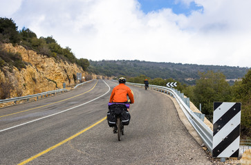 Male cyclist riding bike along road. Sunny day