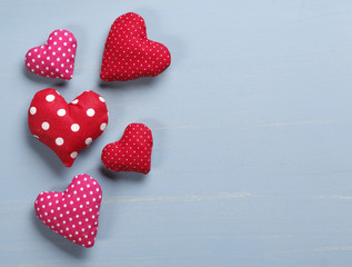 Spotted heart shaped pillows on rustic wooden background