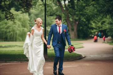 Fototapeta premium beautiful wedding couple in park. kiss and hug each other