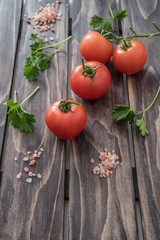 Tomatoes parsley and salt on wooden background