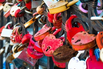 Love locks in the shape of heart painted red color on bridge