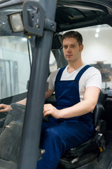Handsome forklift operator working in the warehouse.