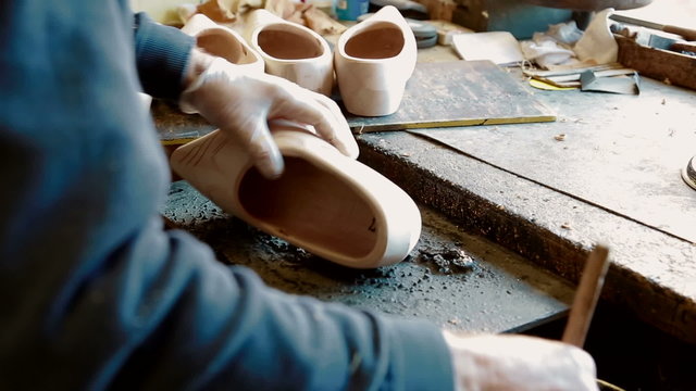 Clog maker is painting a clog black