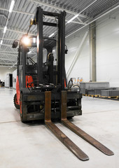 Orange forklift loader in the modern warehouse. - obrazy, fototapety, plakaty