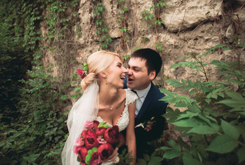 Stylish beautiful couple of happy newlyweds on a walk in the sunny autumn park on their wedding day