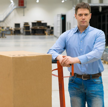 Male worker with boxes at warehouse.
