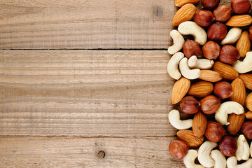 Hazelnuts, almonds and cashew nuts on wooden table top view