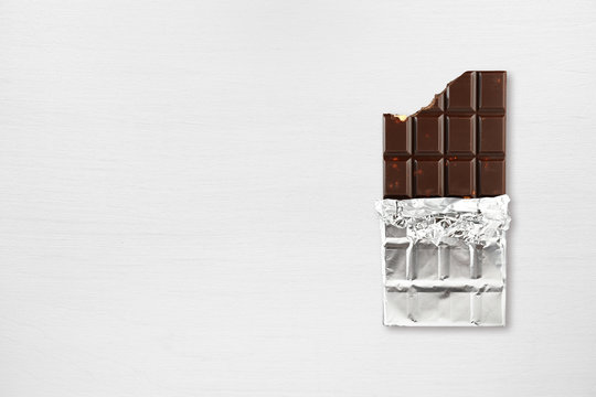Chocolate bar on white wooden table