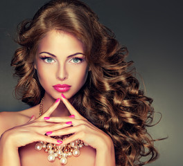 Beautiful model brunette with long curled hair . Hairstyle wavy curls . Crimson nails manicure .Makeup color fuchsia .    © Sofia Zhuravetc