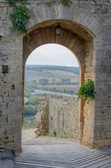 City gate in Monteriggioni with view on Tuscan countryside