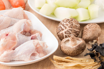 Raw chicken legs with fresh vegetable on wooden.
