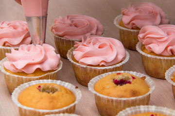 applying cream on cupcakes