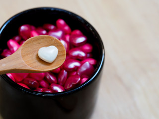 white heart shape sugar candy and wooden spoon with pink heart shape background, valentine day love heart