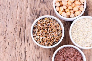 Bowls of various legumes and seeds. Lentils, sesame seeds, pistachio nuts, flaxseed, raisins, peanuts, chickpeas.  