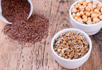 Bowls of various legumes and seeds. Flaxseed, peanuts, chickpeas.  