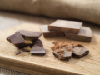 Defocused of Dark chocolate cocoa on wooden board  ( For background )