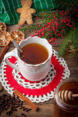 Winter hot drink with spices on wooden table.